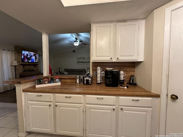 bar with ceiling fan, butcher block counters, light tile patterned floors, and white cabinets