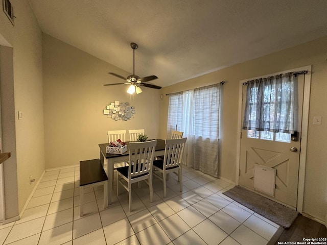 tiled dining space featuring vaulted ceiling and ceiling fan