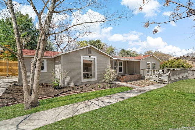 view of front of house featuring a front lawn and a deck