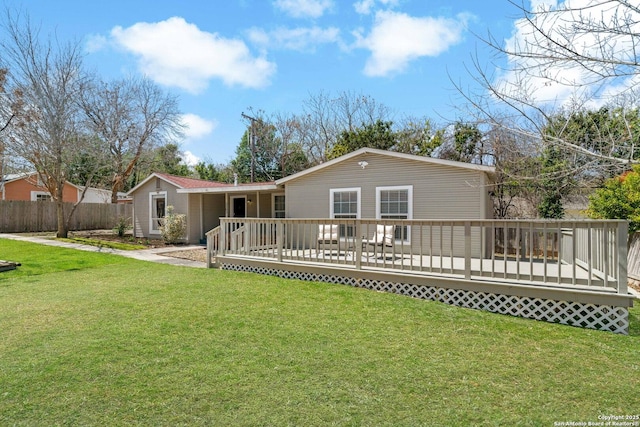 rear view of house featuring a wooden deck and a lawn