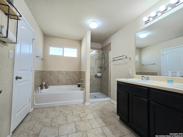 bathroom with shower with separate bathtub, tile patterned floors, vanity, and a textured ceiling