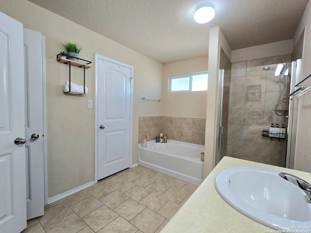 bathroom featuring tile patterned flooring, separate shower and tub, sink, and a textured ceiling