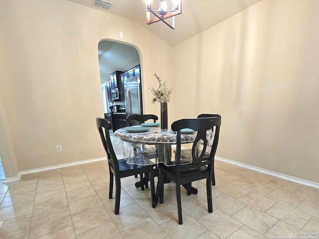 dining space with light tile patterned flooring, lofted ceiling, and an inviting chandelier