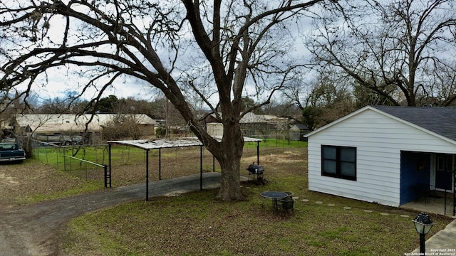 view of yard with a carport and an outbuilding