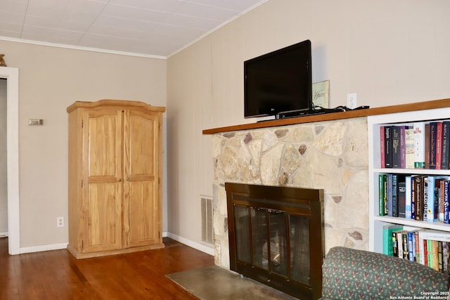 unfurnished living room featuring crown molding, dark wood-type flooring, and a fireplace