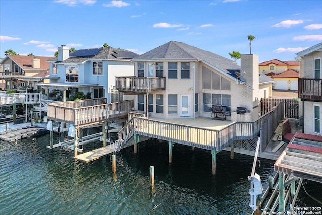 rear view of property featuring a water view and a balcony