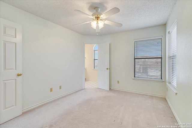 carpeted spare room featuring ceiling fan and a textured ceiling