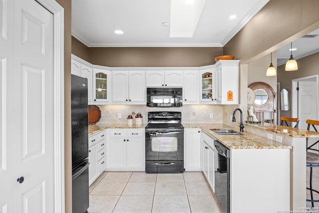 kitchen with black appliances, sink, a kitchen breakfast bar, light stone counters, and kitchen peninsula