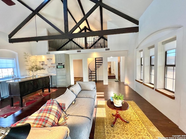 living room featuring beam ceiling, dark hardwood / wood-style flooring, and high vaulted ceiling