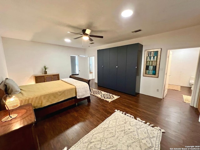 bedroom with ceiling fan, dark hardwood / wood-style flooring, and ensuite bath