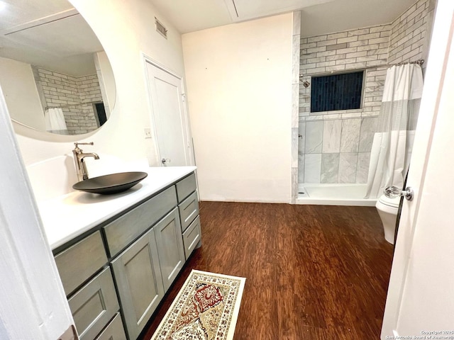 bathroom with vanity, wood-type flooring, toilet, and walk in shower