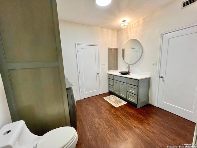 bathroom featuring vanity, hardwood / wood-style floors, and toilet