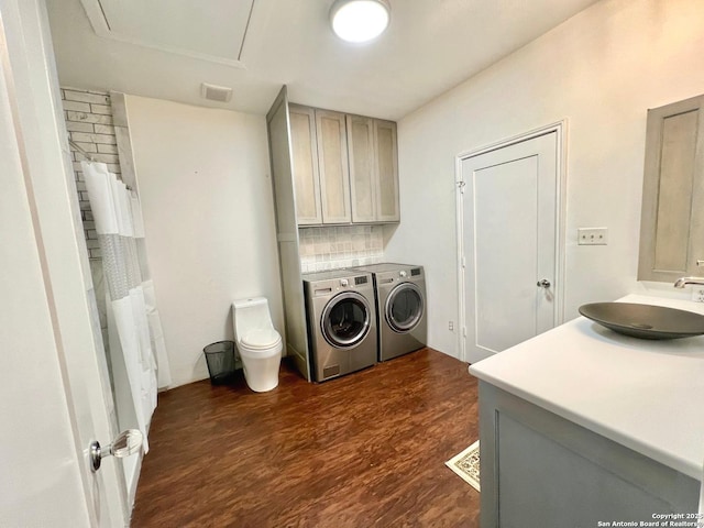 laundry room featuring dark wood-type flooring, sink, and washer and dryer