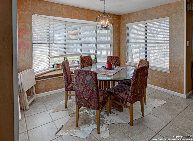 dining space with light tile patterned flooring and a chandelier