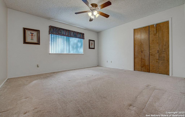 unfurnished bedroom with light carpet, a textured ceiling, a closet, and ceiling fan