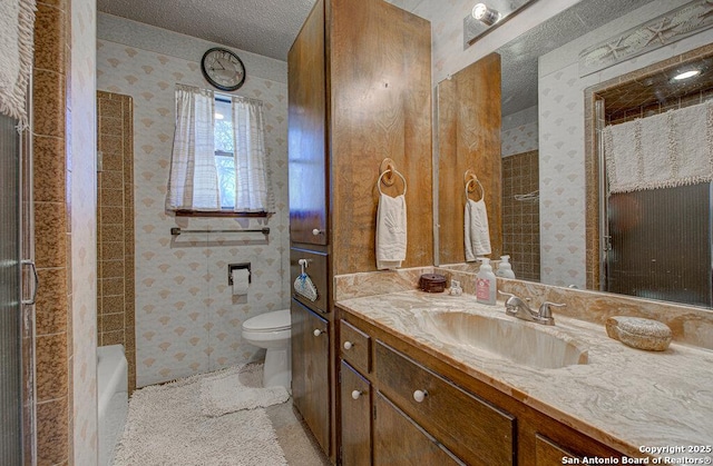 bathroom featuring walk in shower, vanity, toilet, and a textured ceiling