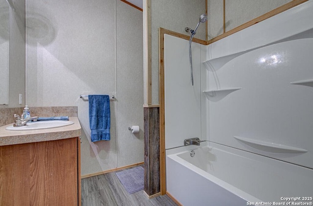 bathroom with washtub / shower combination, vanity, and hardwood / wood-style floors