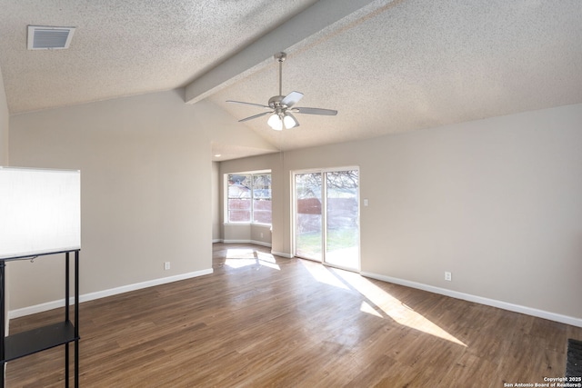 empty room with ceiling fan, wood-type flooring, lofted ceiling with beams, and a textured ceiling