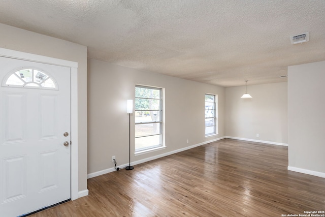 foyer with wood-type flooring and a textured ceiling