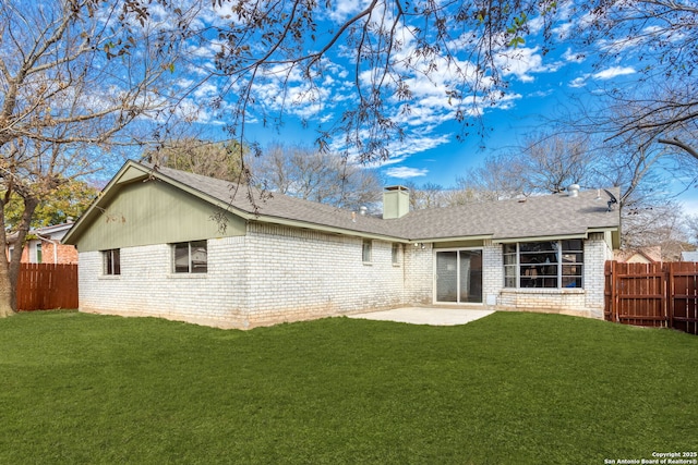 back of house featuring a patio area and a lawn