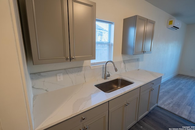 kitchen featuring gray cabinets, light stone countertops, sink, and dark hardwood / wood-style flooring