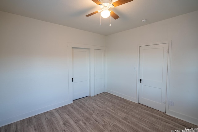 unfurnished bedroom with ceiling fan and light hardwood / wood-style floors