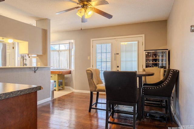 dining area with dark wood-type flooring, french doors, baseboards, and a ceiling fan