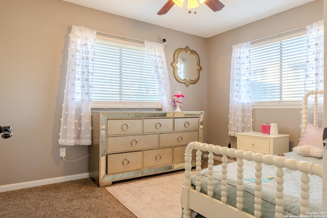 bedroom with a ceiling fan, light carpet, and baseboards