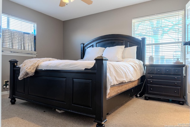 carpeted bedroom featuring ceiling fan and multiple windows