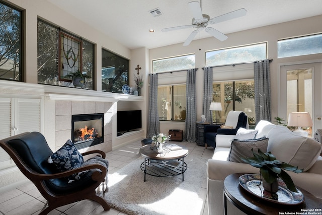 interior space featuring ceiling fan and a tiled fireplace