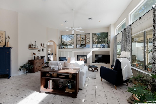 living room with light tile patterned floors, a fireplace, and ceiling fan