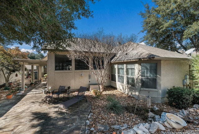 back of property featuring a patio and a pergola