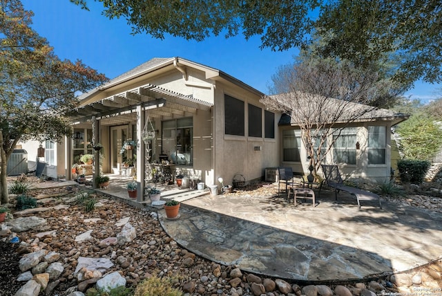 back of house with a pergola and a patio