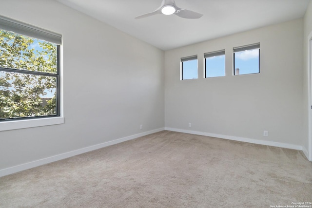 carpeted spare room with ceiling fan