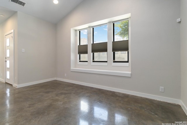 empty room featuring lofted ceiling