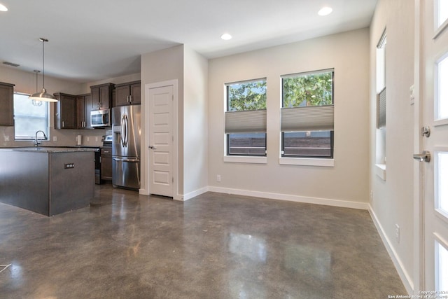 kitchen featuring pendant lighting, dark brown cabinetry, appliances with stainless steel finishes, and sink