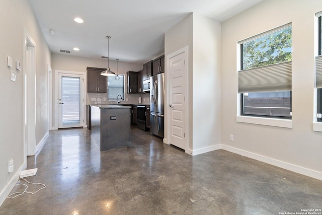 kitchen with dark brown cabinetry, sink, decorative light fixtures, a center island, and stainless steel appliances