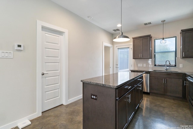 kitchen with sink, dark stone countertops, hanging light fixtures, dark brown cabinets, and a kitchen island