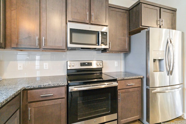 kitchen featuring stone countertops, tasteful backsplash, and appliances with stainless steel finishes