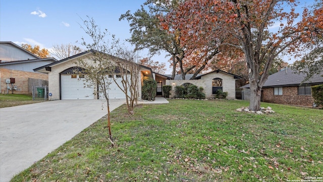 ranch-style house featuring a garage and a front yard