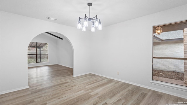 unfurnished dining area featuring light wood-type flooring and an inviting chandelier