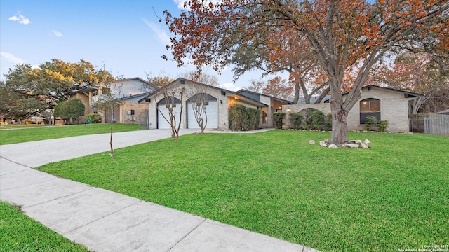 ranch-style house featuring a garage and a front lawn