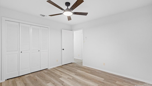 unfurnished bedroom with light wood-type flooring, ceiling fan, and a closet