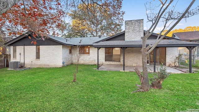 back of property with cooling unit, a patio area, and a lawn