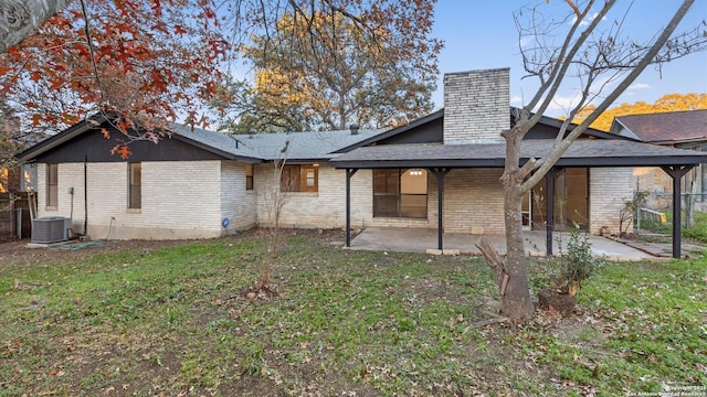 back of property with a yard, central AC unit, and a patio area