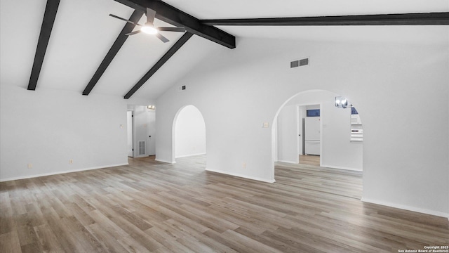 unfurnished living room with ceiling fan with notable chandelier, high vaulted ceiling, beamed ceiling, and light wood-type flooring