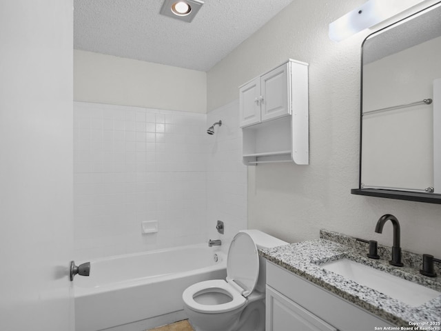 full bathroom featuring vanity, tiled shower / bath combo, toilet, and a textured ceiling