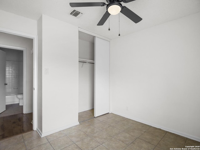 unfurnished bedroom featuring a closet, ceiling fan, and ensuite bathroom