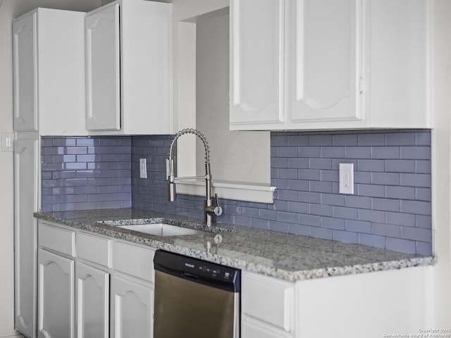 kitchen featuring white cabinetry, stainless steel dishwasher, light stone countertops, and tasteful backsplash