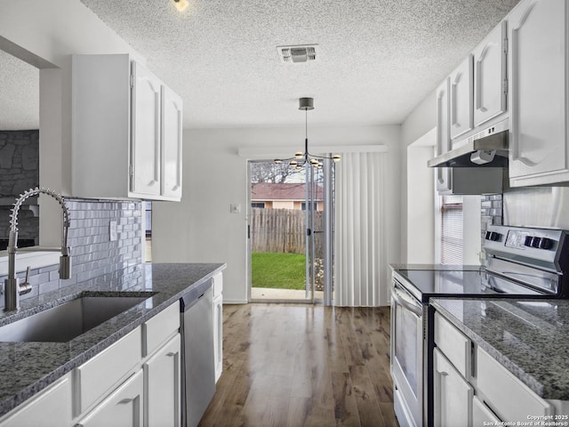 kitchen featuring sink, white cabinetry, appliances with stainless steel finishes, pendant lighting, and backsplash